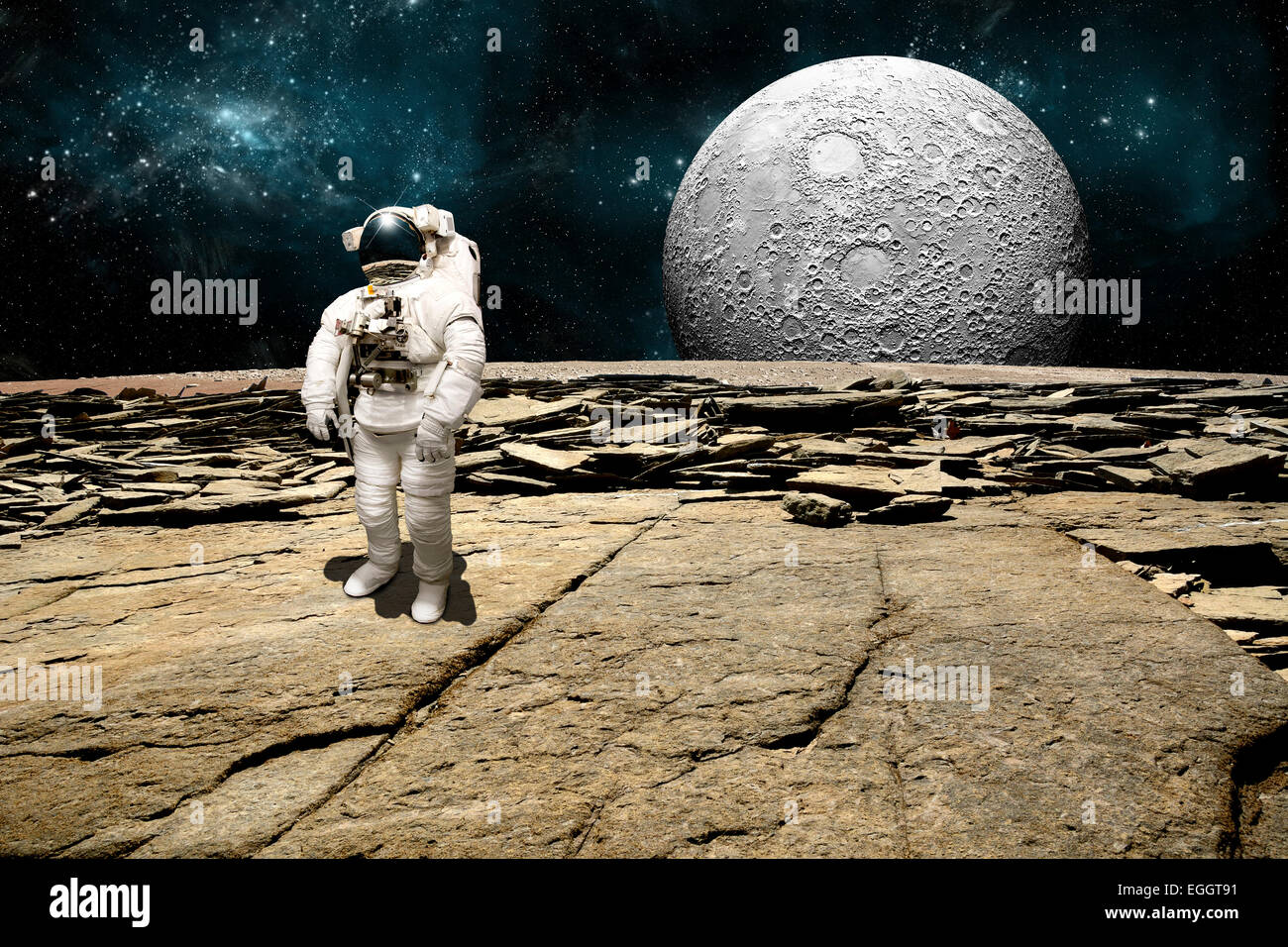 Un astronauta sondaggi la sua situazione dopo essere stata fregata su un pianeta sterile. Un grande, pesantemente ingabbiati luna sorge all'orizzonte. Foto Stock