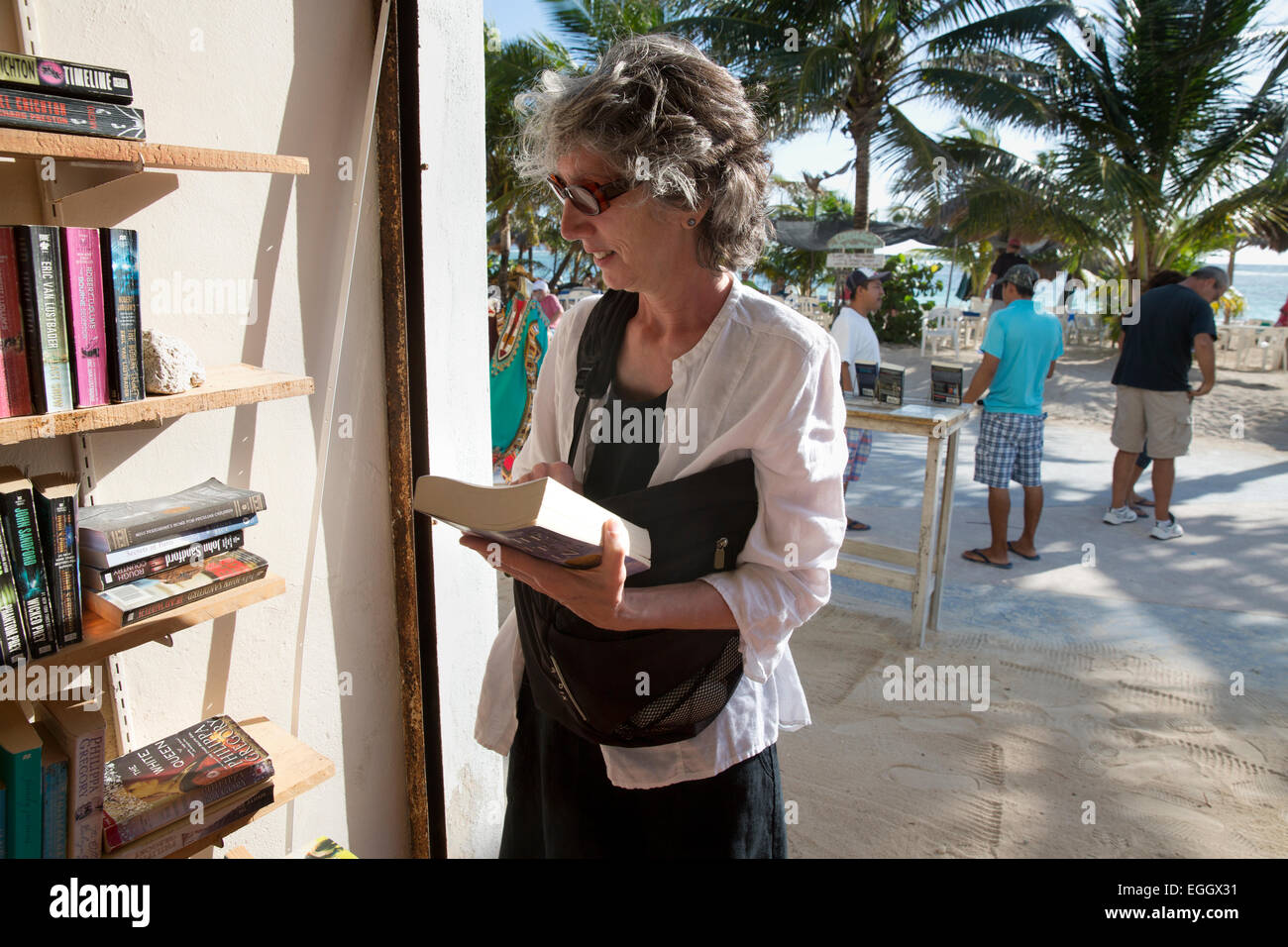 Una donna shopping per libri di seconda mano in Mahahual, Quintana Roo, Messico Foto Stock