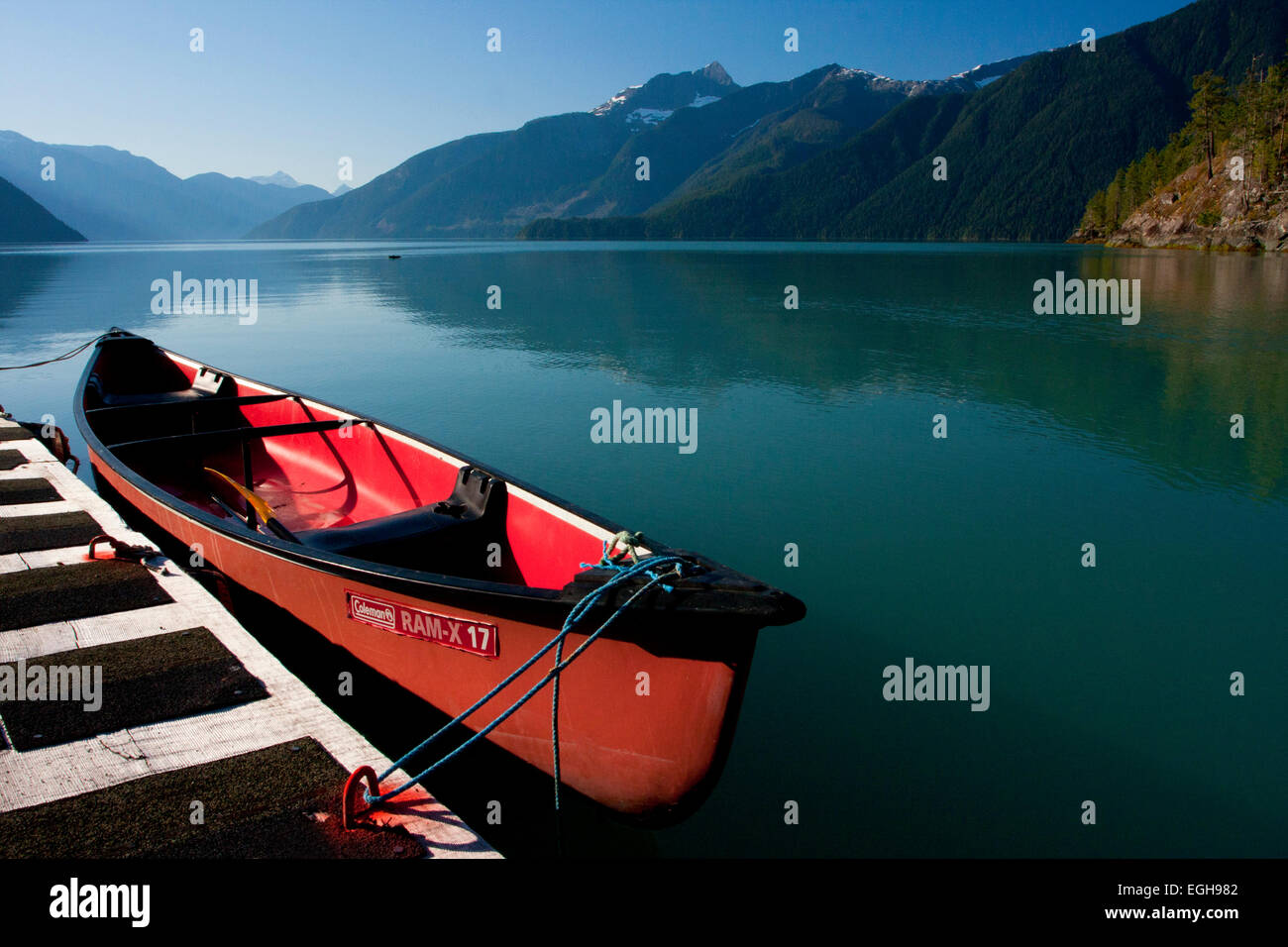 Una canoa ormeggiata a bordo di una chiatta lungo la Bute ingresso, BC, Canada nel mese di settembre Foto Stock