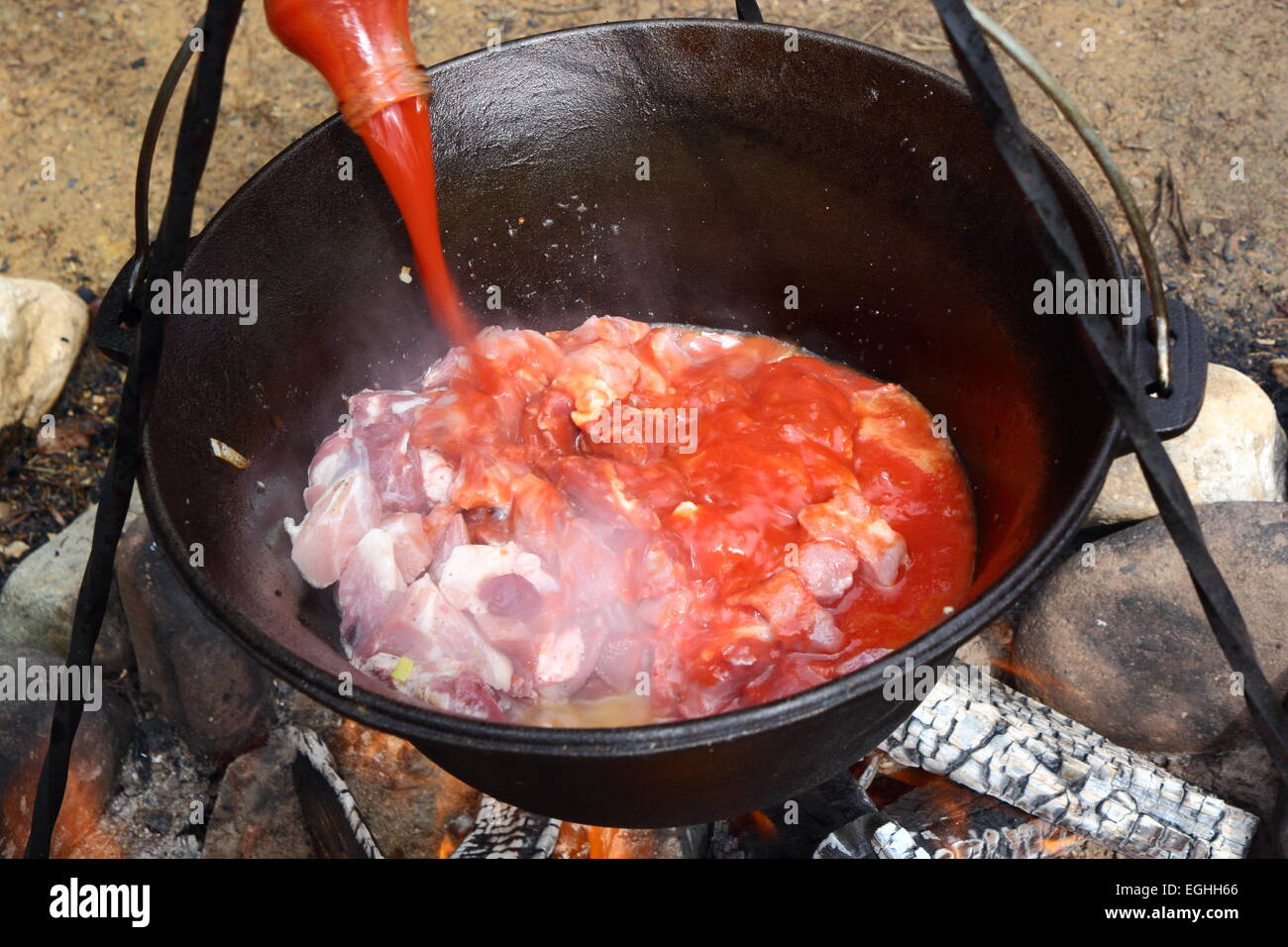 La preparazione di osso buco all'aperto nel calderone tradizionali Foto Stock