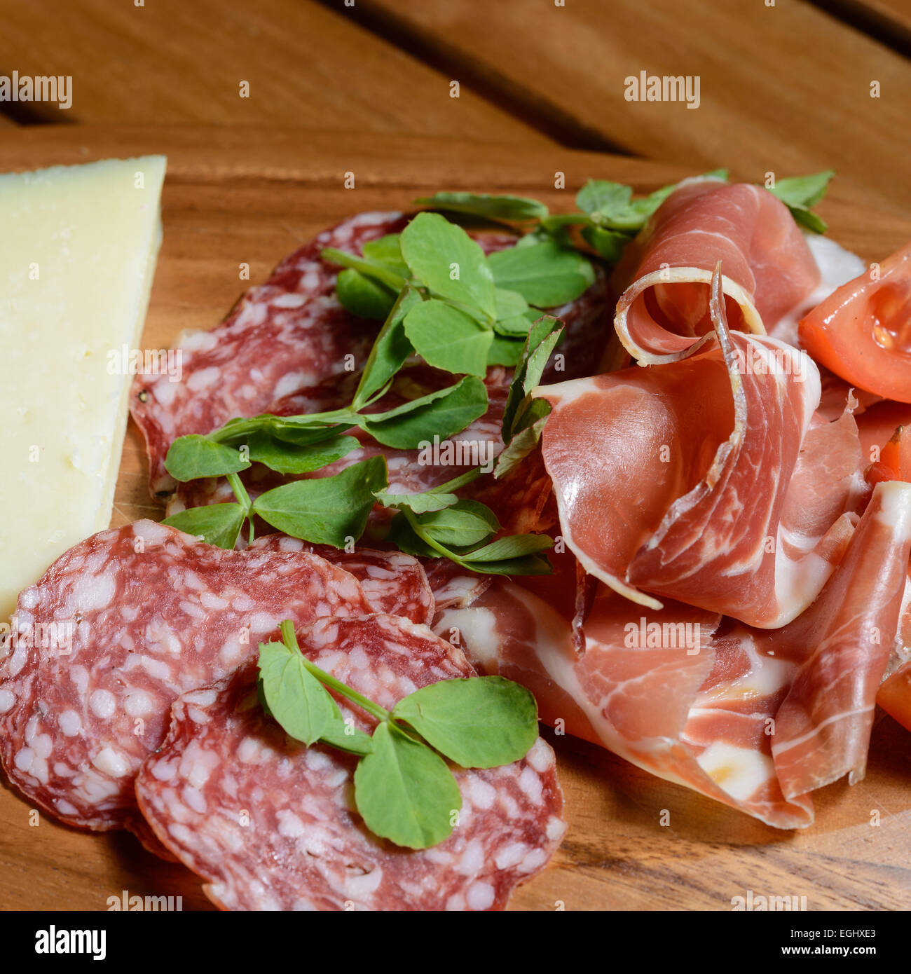 Tapas Scheda Antipasti: Prosciutto Serrano, Salchicon salami, insalata di pomodoro e formaggio Manchego decorate con pisello verde foglie. Foto Stock