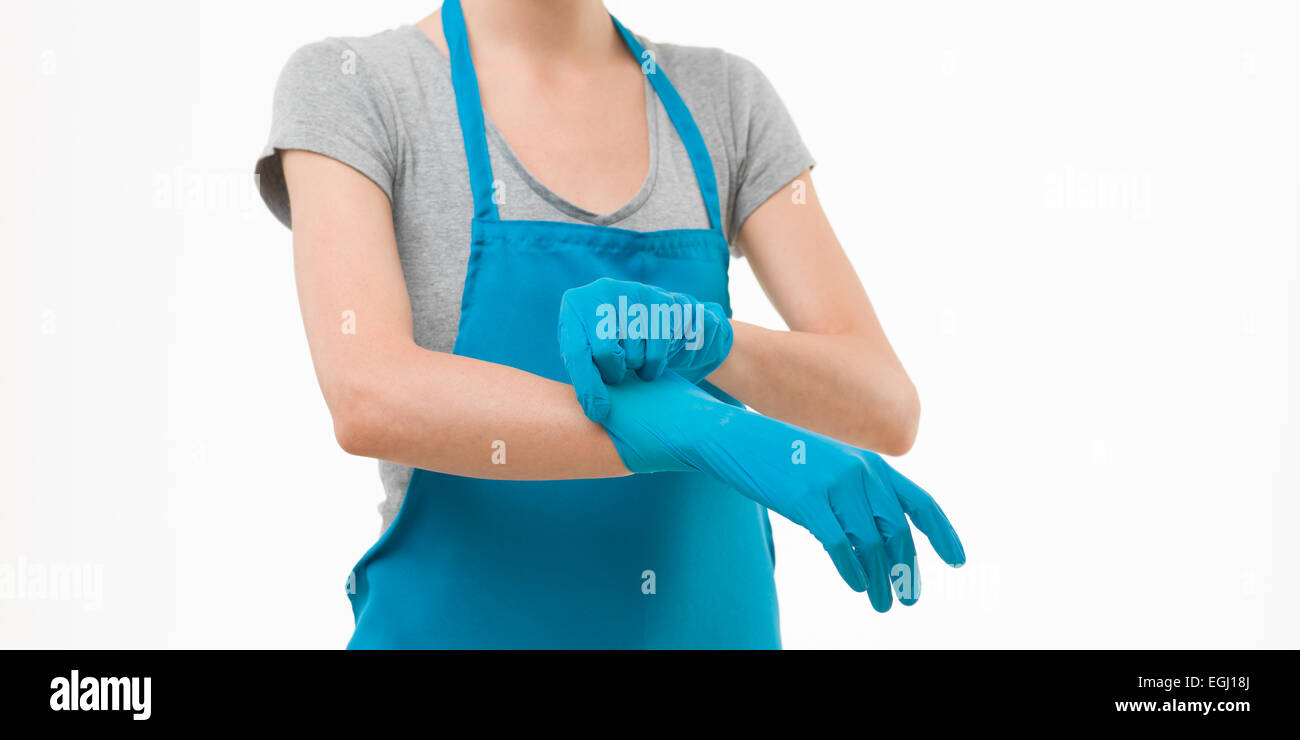 Pulizia caucasica donna mettendo i guanti di gomma sulle sue mani, isolato su sfondo bianco Foto Stock