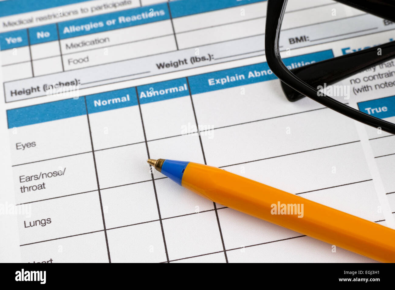 Pagina della storia di salute formano con pre-partecipazione informazioni fisiche. Ci sono gli occhiali e penna a sfera sulla pagina. Foto Stock