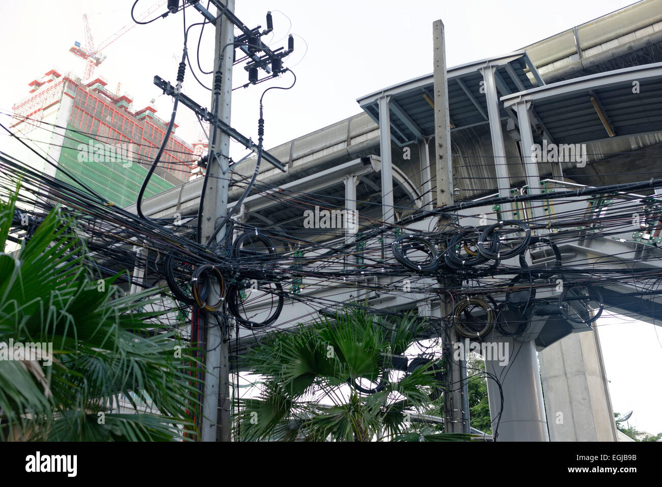 Caotica overhead disordinato potenza elettrica cavi per telecomunicazioni a Bangkok in Tailandia in Asia Foto Stock