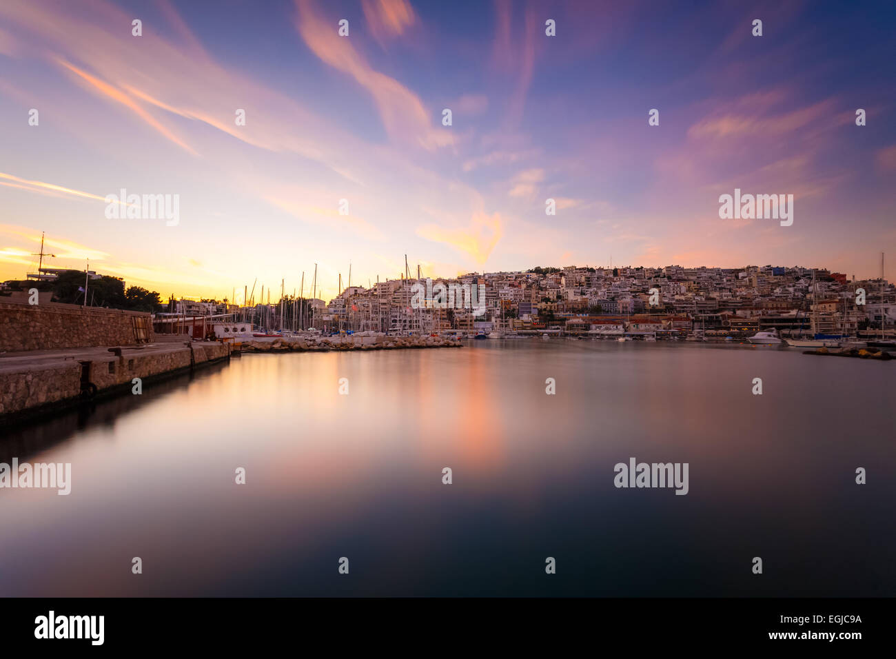 Tipica serata colorata scenario in Mikrolimano marina Atene nel pomeriggio con nuvole sopra le luci della città in Grecia Foto Stock