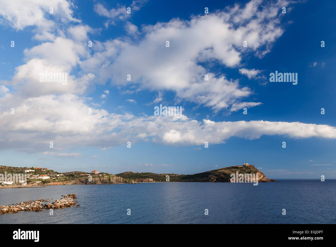 Il tempio di Poseidone a Sunio, Grecia contro un blu cielo nuvoloso, shot presi da di fronte alla baia, lunga esposizione foto Foto Stock