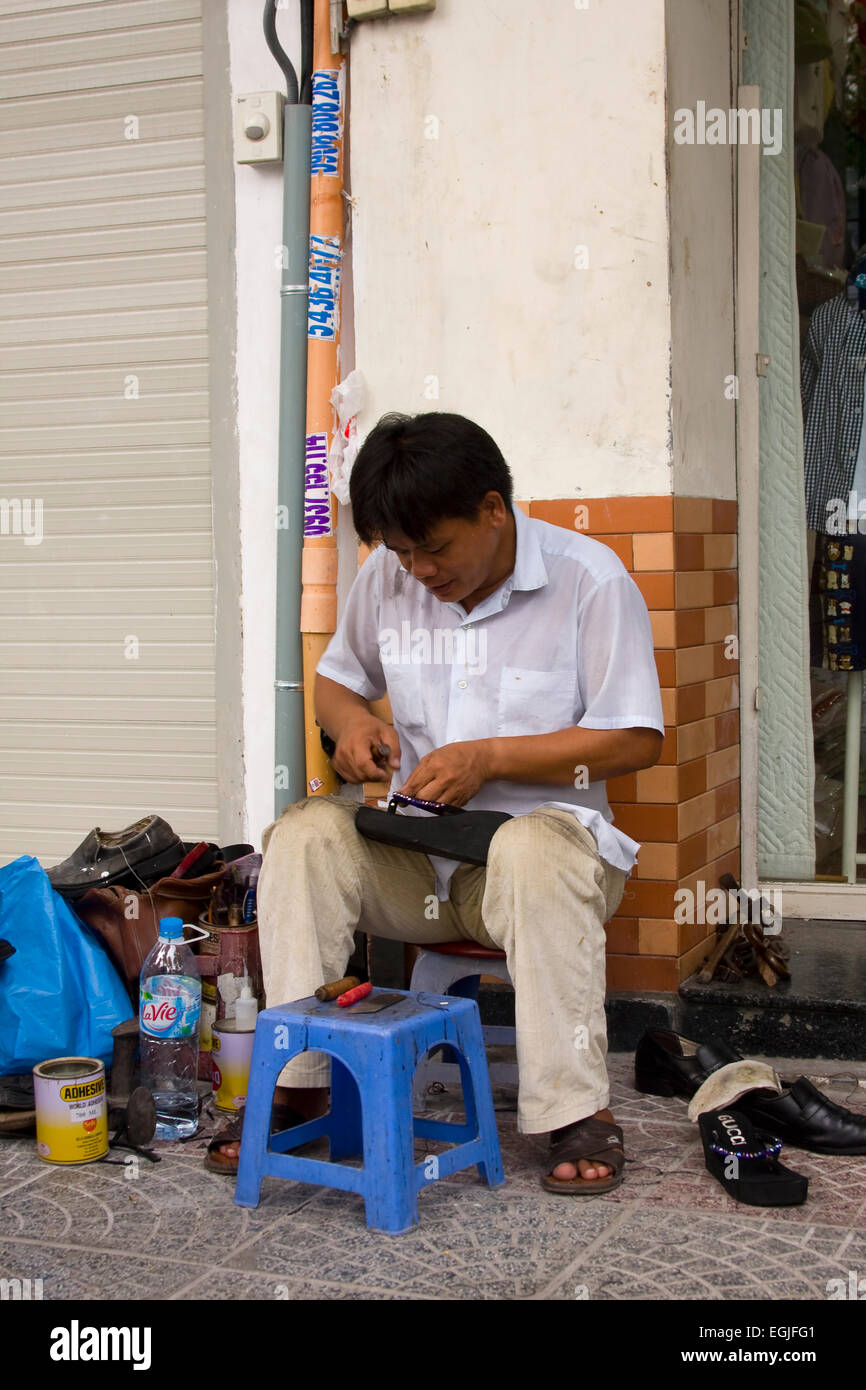 Street calzolaio riparazione di scarpe, a Saigon, a Ho Chi Minh City, Vietnam Asia Foto Stock