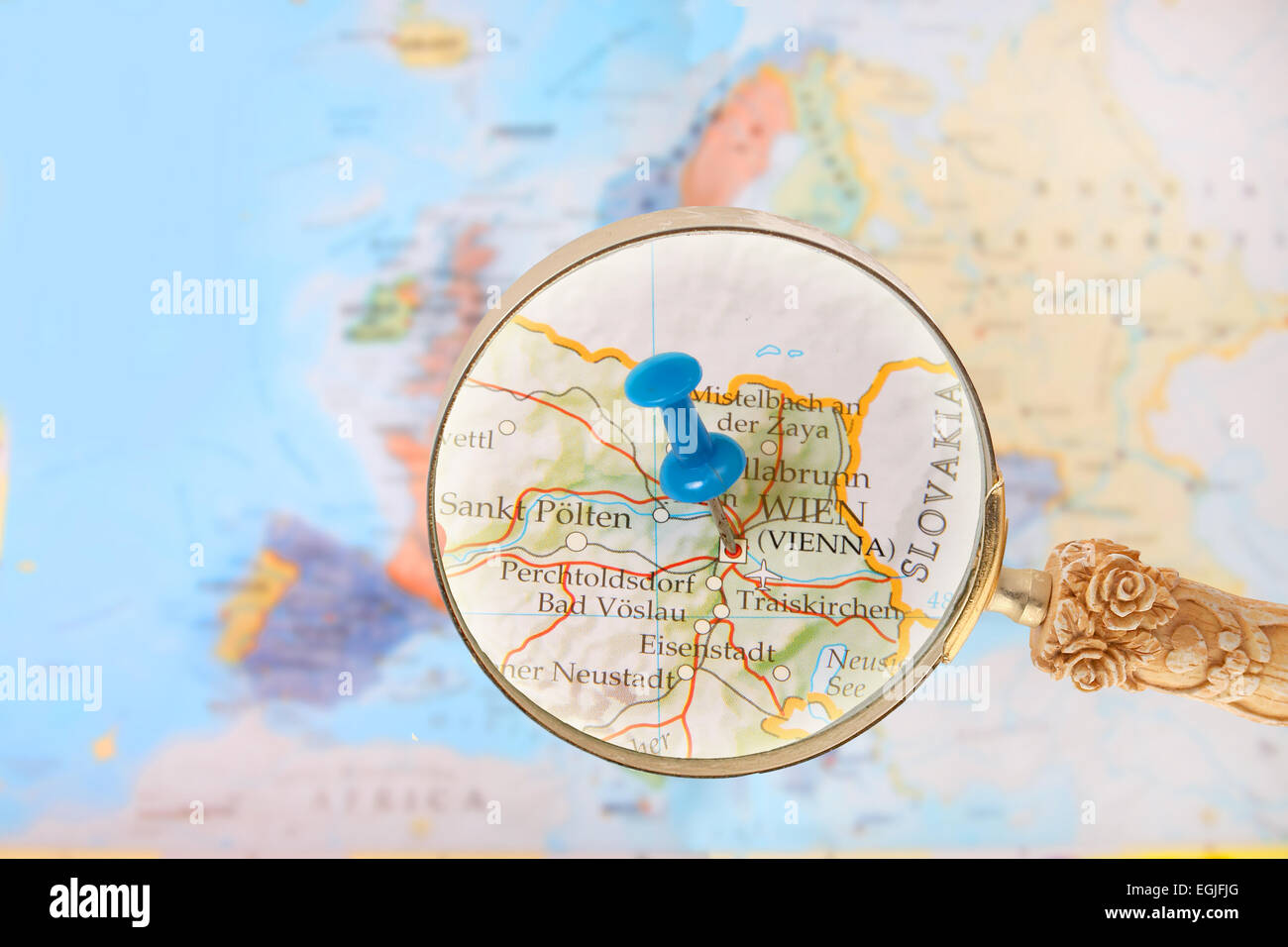 Blu Tack sulla mappa di Europa con lente di ingrandimento cercando in su Vienna, Austria Foto Stock