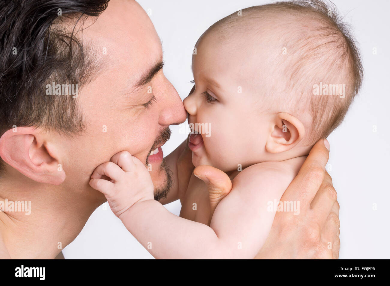 Close up di un padre tiene il suo bambino e sorridente ad ogni altro. Foto Stock