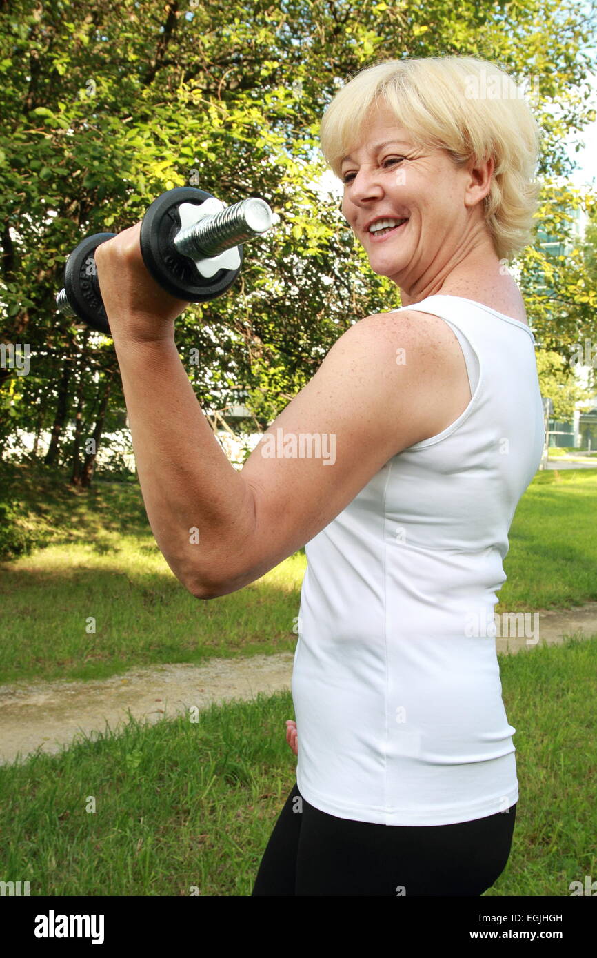 Una donna anziana outdoor training con il manubrio Foto Stock