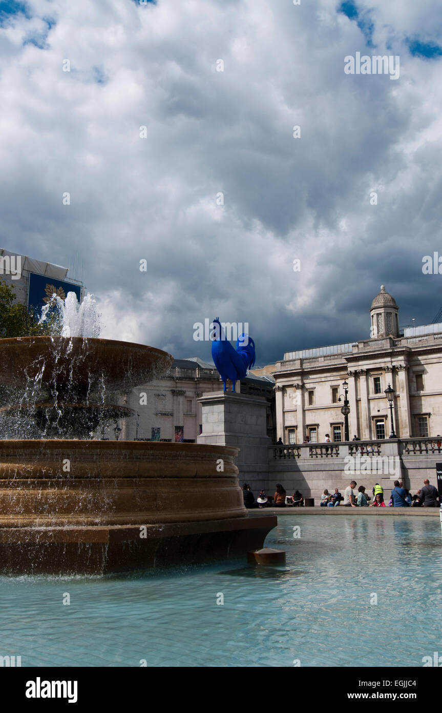 Fontana con Blue galletto scultura al quarto zoccolo in background a Trafalgar Square, Londra Foto Stock