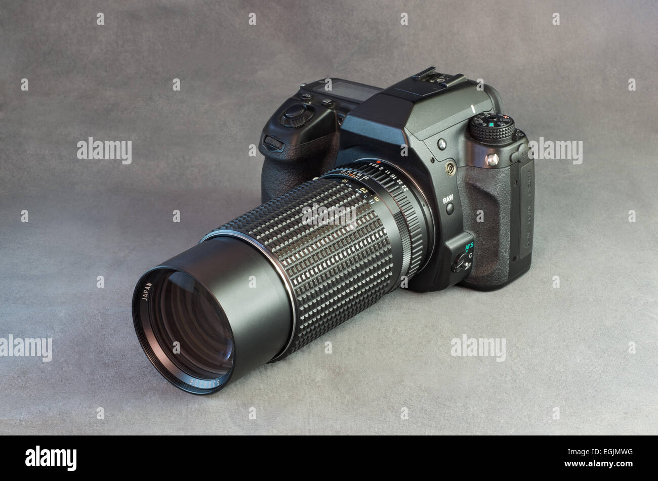 Una fotocamera reflex digitale e un teleobiettivo su sfondo grigio Foto Stock