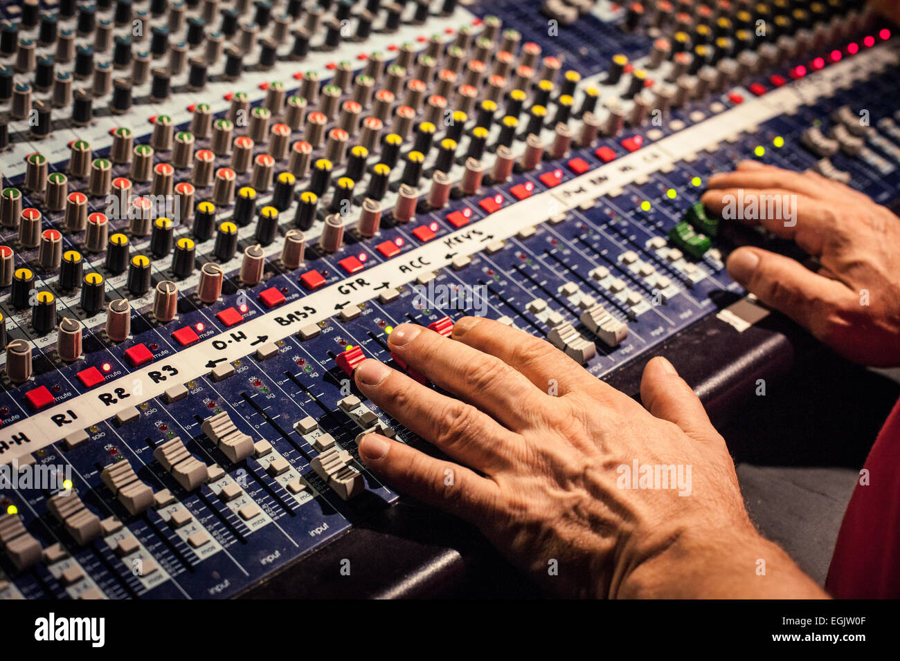 Un uomo con le mani in mano a un mix desk in un concerto di musica Foto Stock