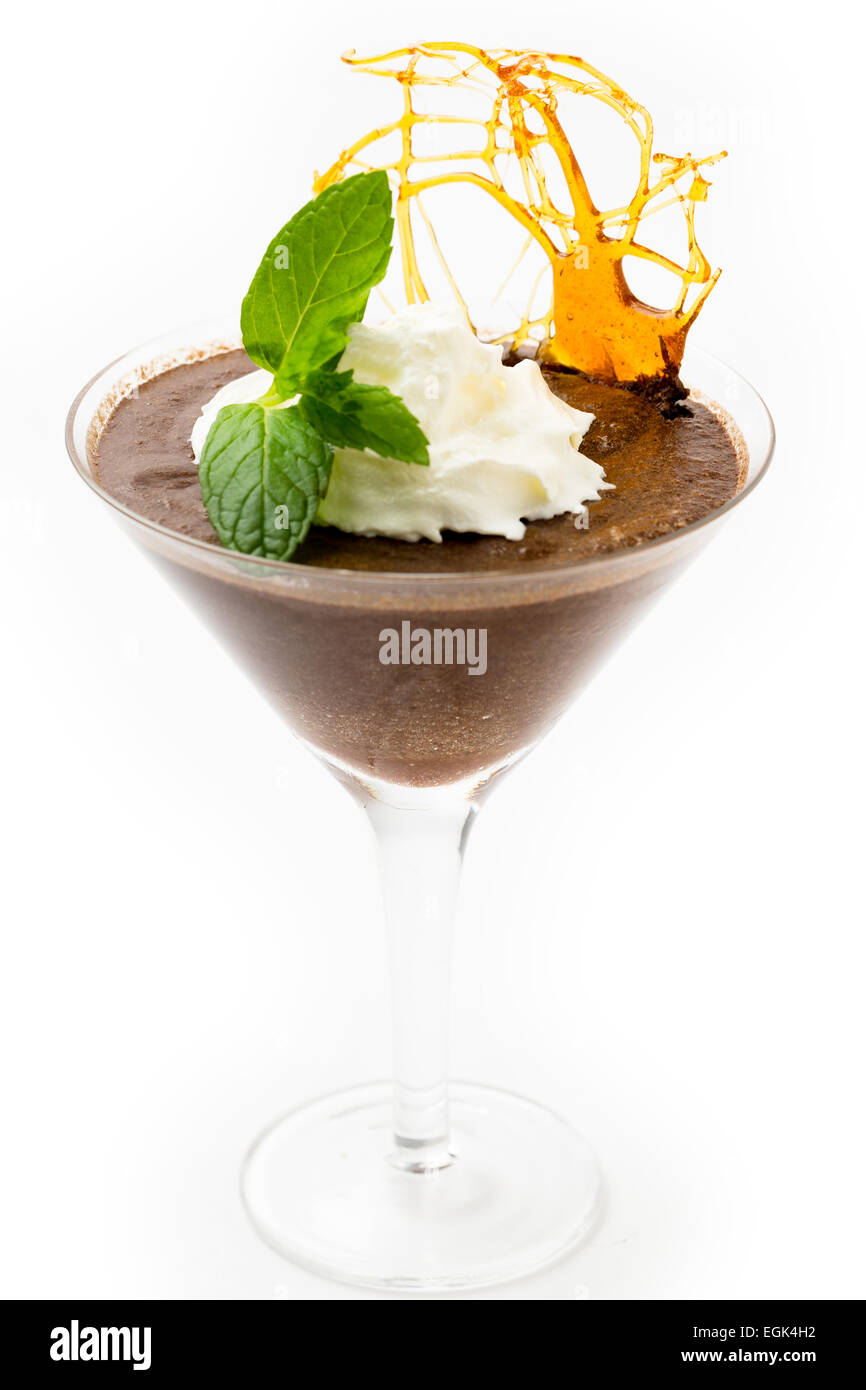 In casa la mousse di cioccolato in una coppetta Martini con crema, un rametto di menta e uno zucchero caramellato decorazione Foto Stock