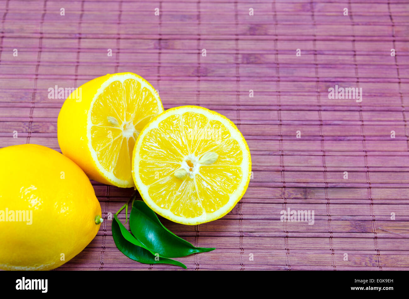 Dimezzato i limoni su una tabella di bambù Foto Stock