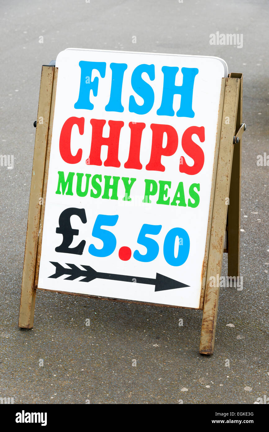 Un segno pubblicità board per pesce e patatine e fiacco piselli sul lungomare nel Regno Unito Foto Stock
