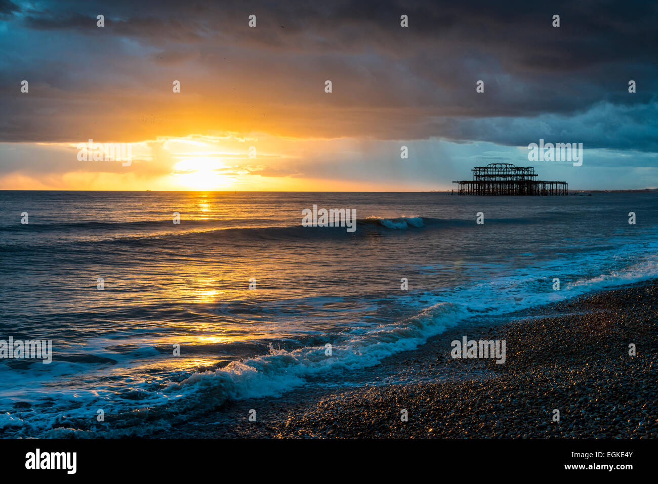 Sunset seascape su una burrascosa serata presso il vecchio molo Ovest di Brighton Regno Unito Foto Stock
