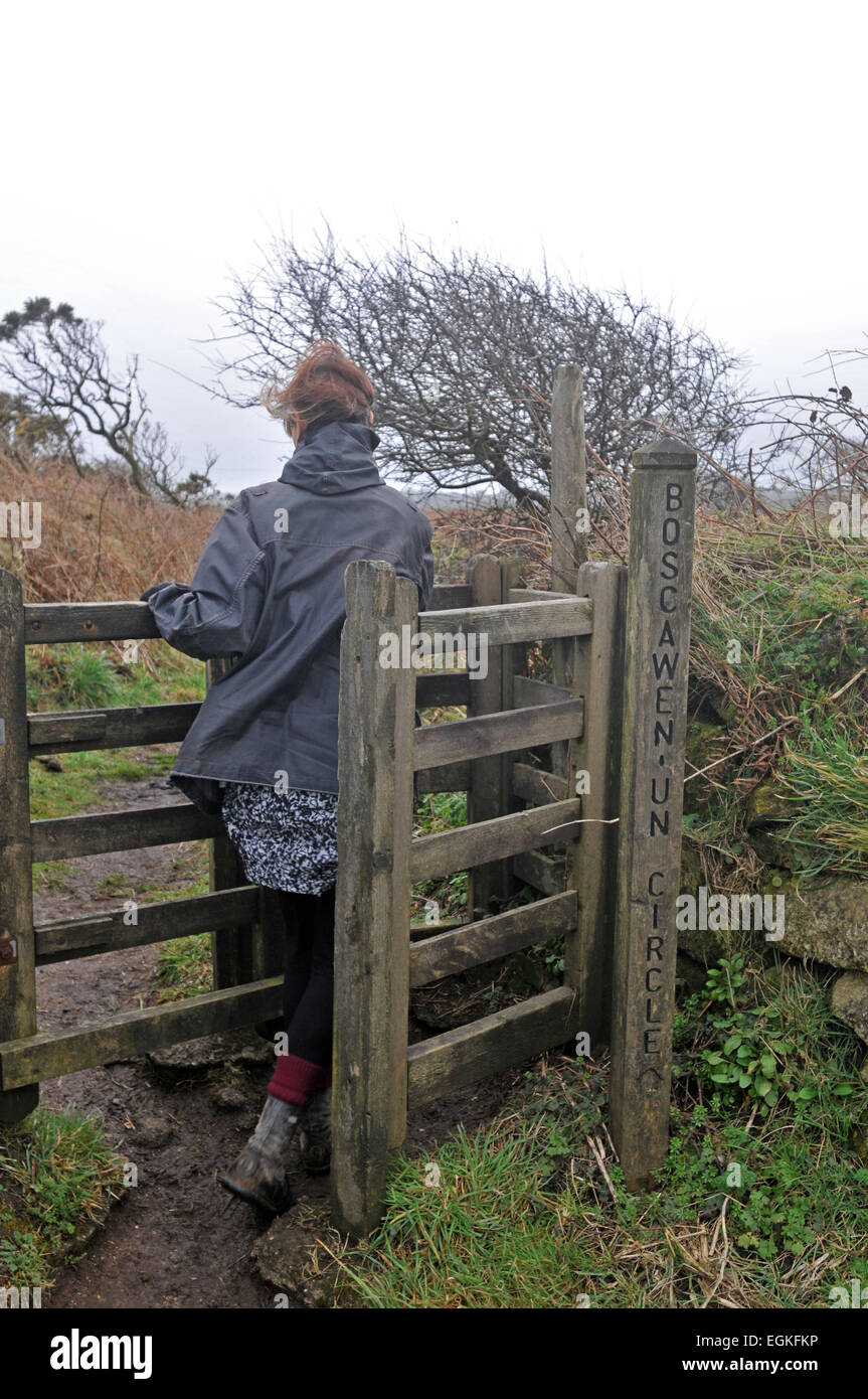 Una femmina di walker passa attraverso uno stile nella campagna della Cornovaglia Foto Stock