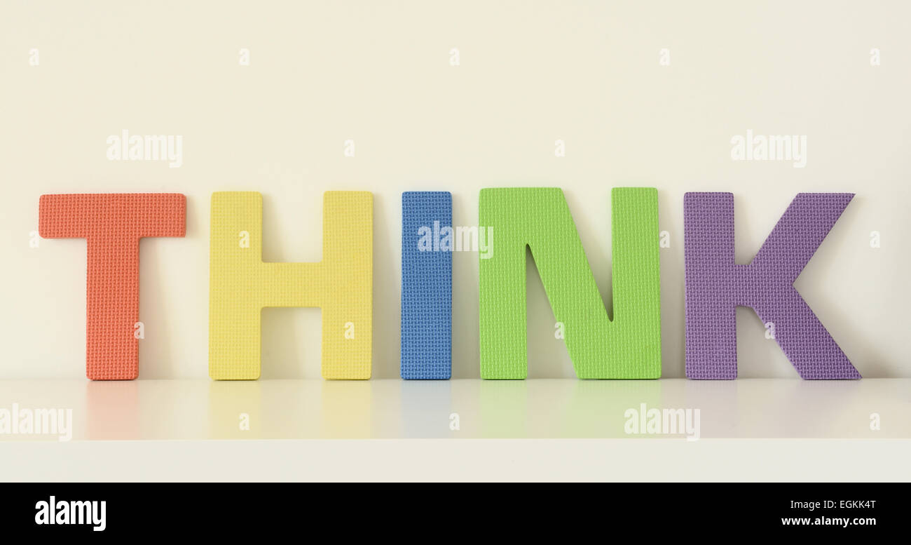 Parola THINK, in colorate in lettere maiuscole di giocattoli di schiuma sulla superficie bianca Foto Stock
