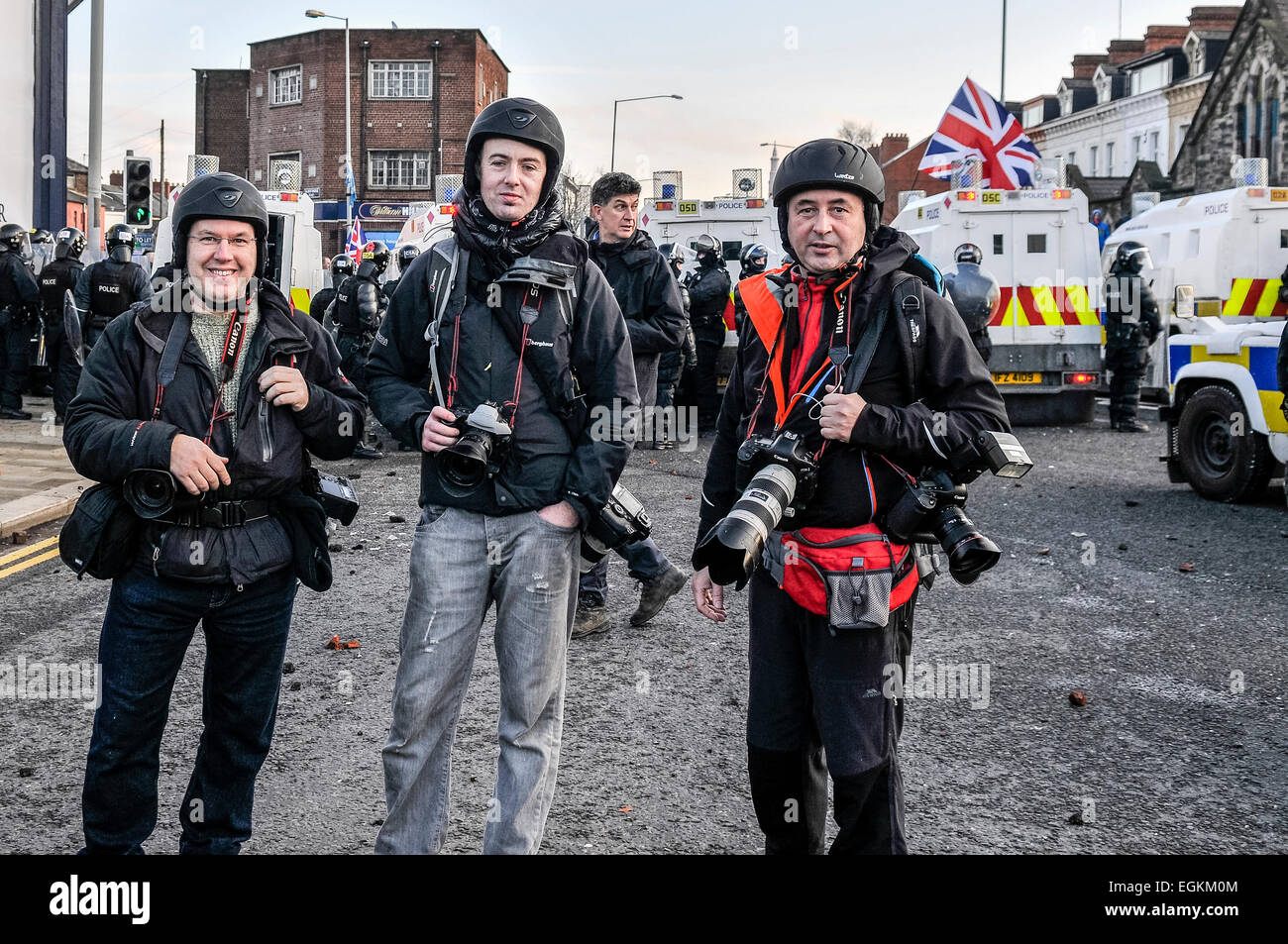 Belfast, Irlanda del Nord. 12 gen 2013 - Tre premi fotografi indossare i caschi di protezione mentre si fotografa una sommossa. Foto Stock