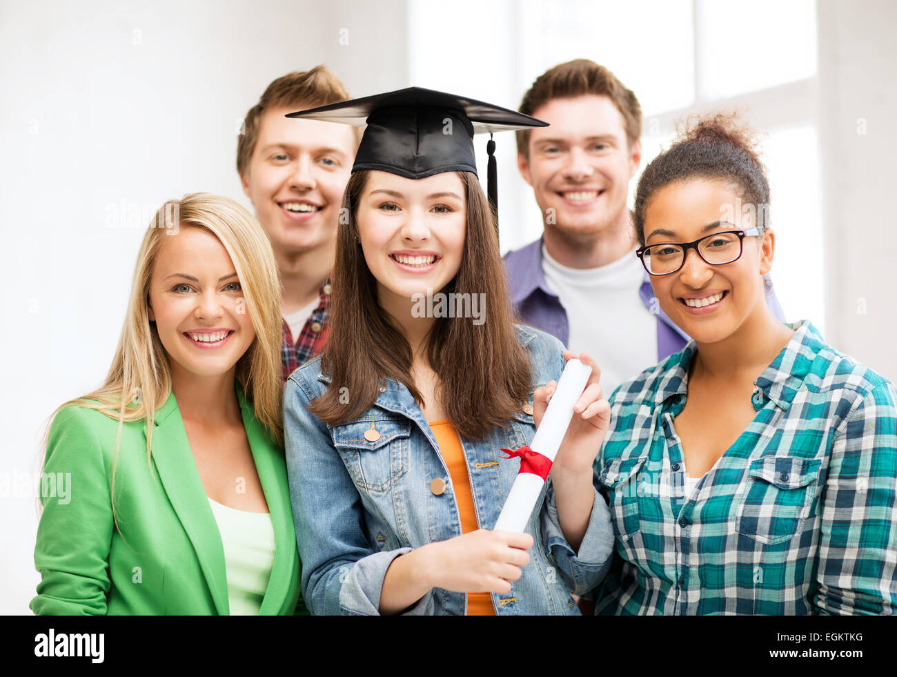 Ragazza nel tappo di graduazione con certificato Foto Stock