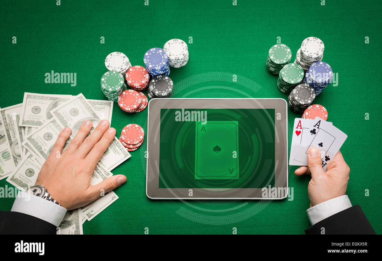 Casinò poker player con cards, tablet e trucioli Foto Stock