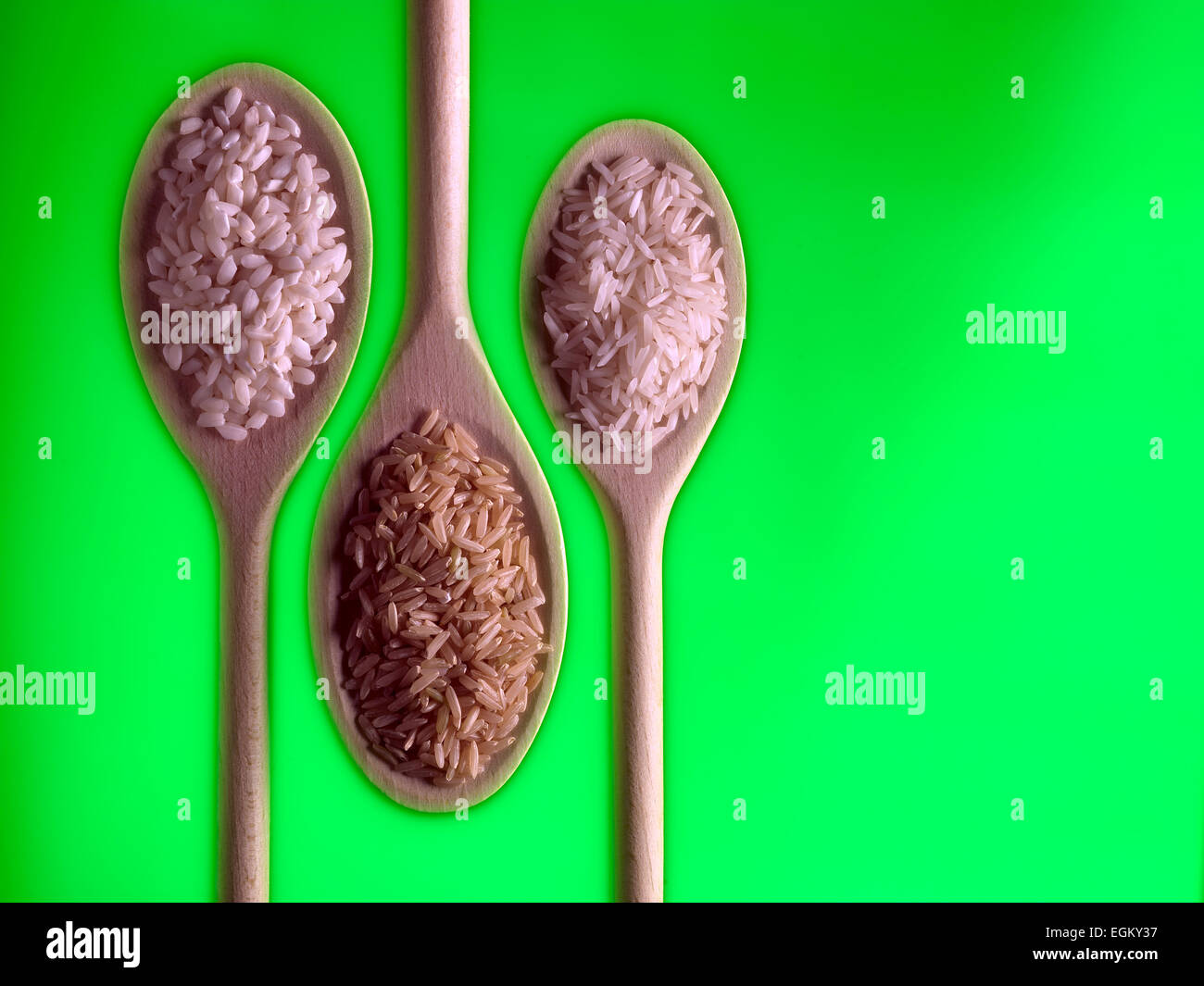 Risotto, Brown & riso basmati su cucchiai di legno Foto Stock