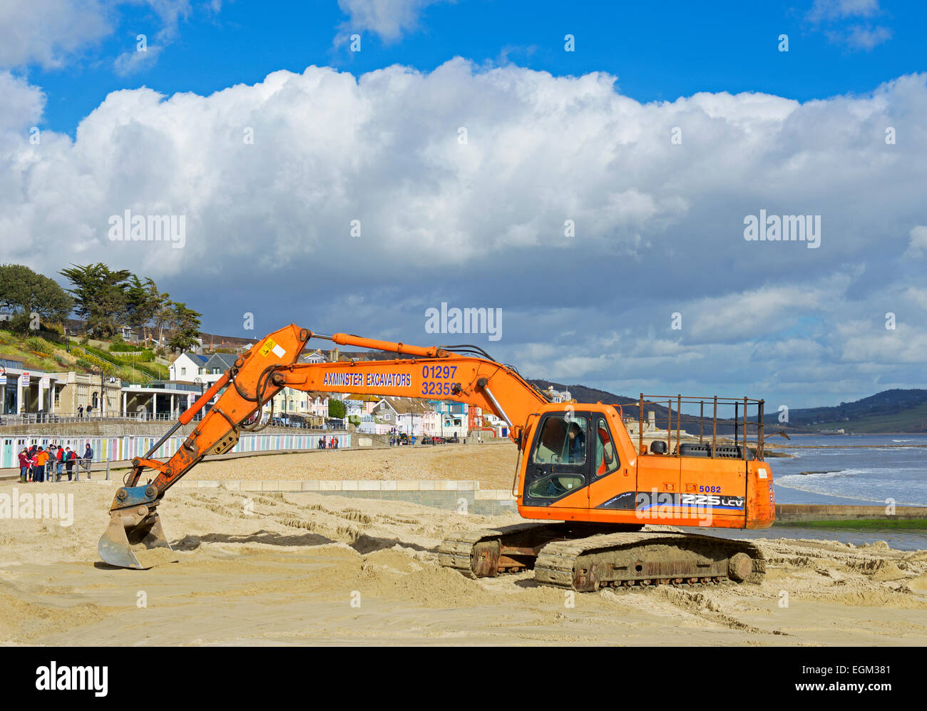 Livellamento della spiaggia di Lyme Regis con un escavatore JCB, Dorset, England Regno Unito Foto Stock