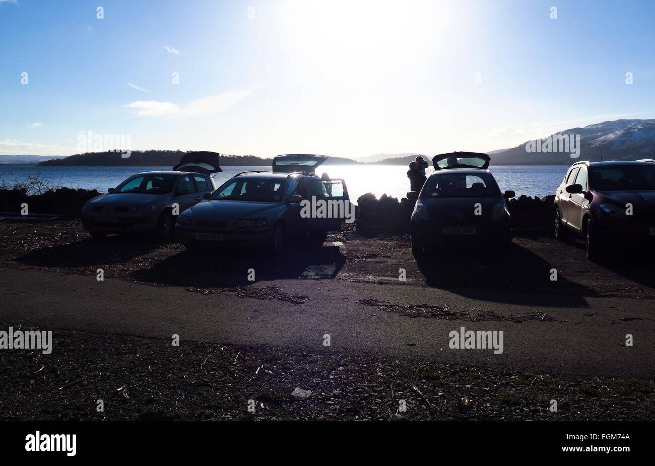 Vetture a lato lago famiglie godendo picnic Foto Stock
