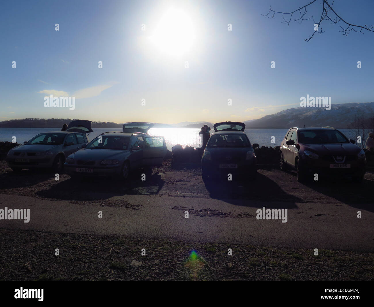 Vetture a lato lago famiglie godendo picnic Foto Stock