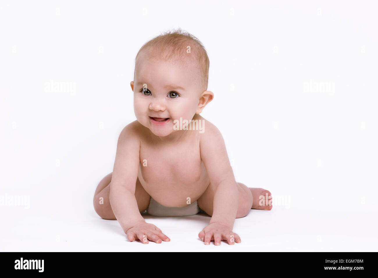 Sorridente baby indossando un pannolino seduta su mani e ginocchia. Girato su sfondo bianco. Foto Stock