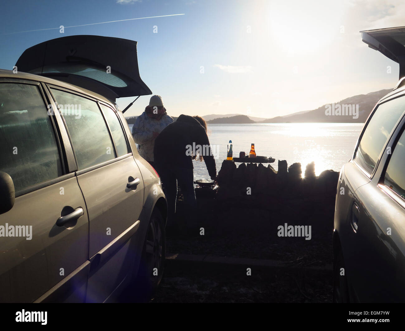 Vetture a lato lago famiglie godendo picnic Foto Stock