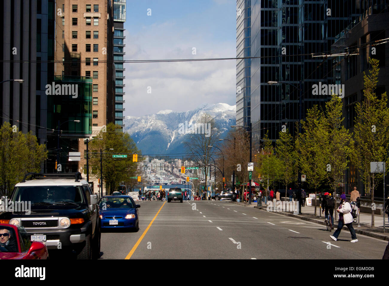 Visualizza in basso Burrard Street, nel quartiere finanziario del centro cittadino di Vancouver, Canada con le North Shore Mountains la distanza Foto Stock