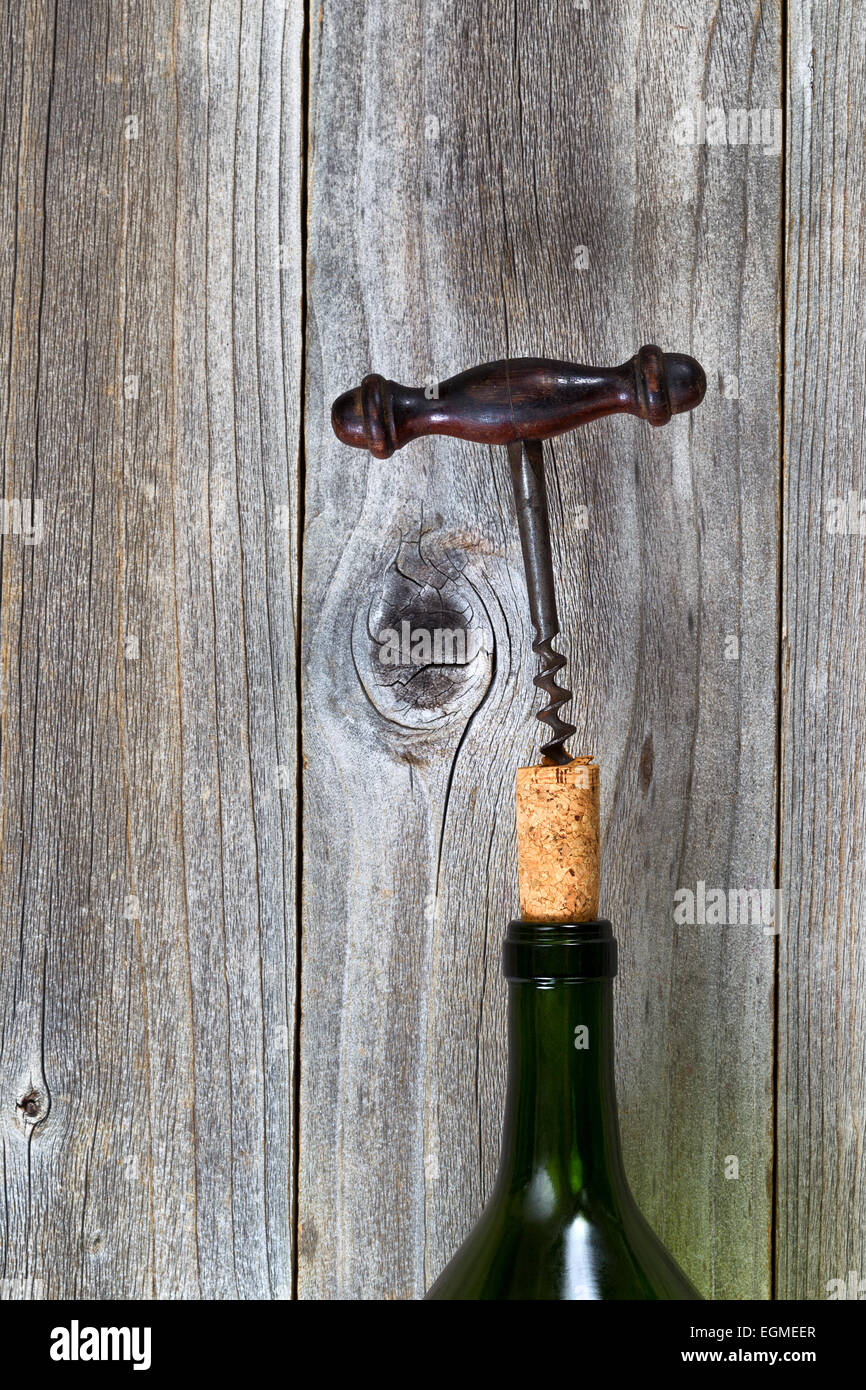 L'immagine verticale di antichi cavatappi tirando fuori il sughero in bottiglia per vino in legno rustico. Foto Stock
