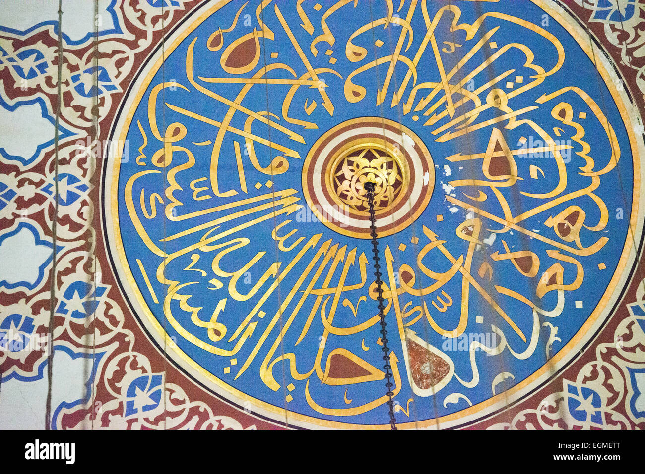 Sultan Ahmed Mosque Dome Calligrafia islamica Istanbul Turchia // ISTANBUL, Turchia — l'apice decorato con decorazioni ornamentali della cupola centrale della Moschea Sultan Ahmed presenta un'intricata calligrafia islamica e motivi geometrici. Il design elaborato della cupola combina versi del Corano con motivi artistici ottomani tradizionali. La decorazione dipinta rappresenta l'altezza dell'arte religiosa ottomana del XVII secolo. Foto Stock