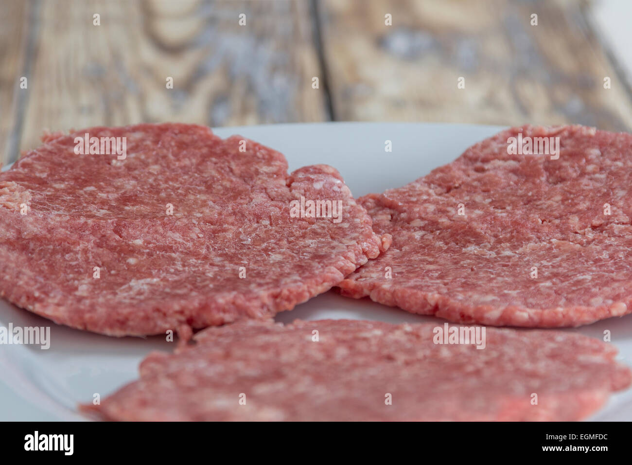 Tre hamburger fatti in casa le polpette su una piastra su una tavola in legno rustico Foto Stock