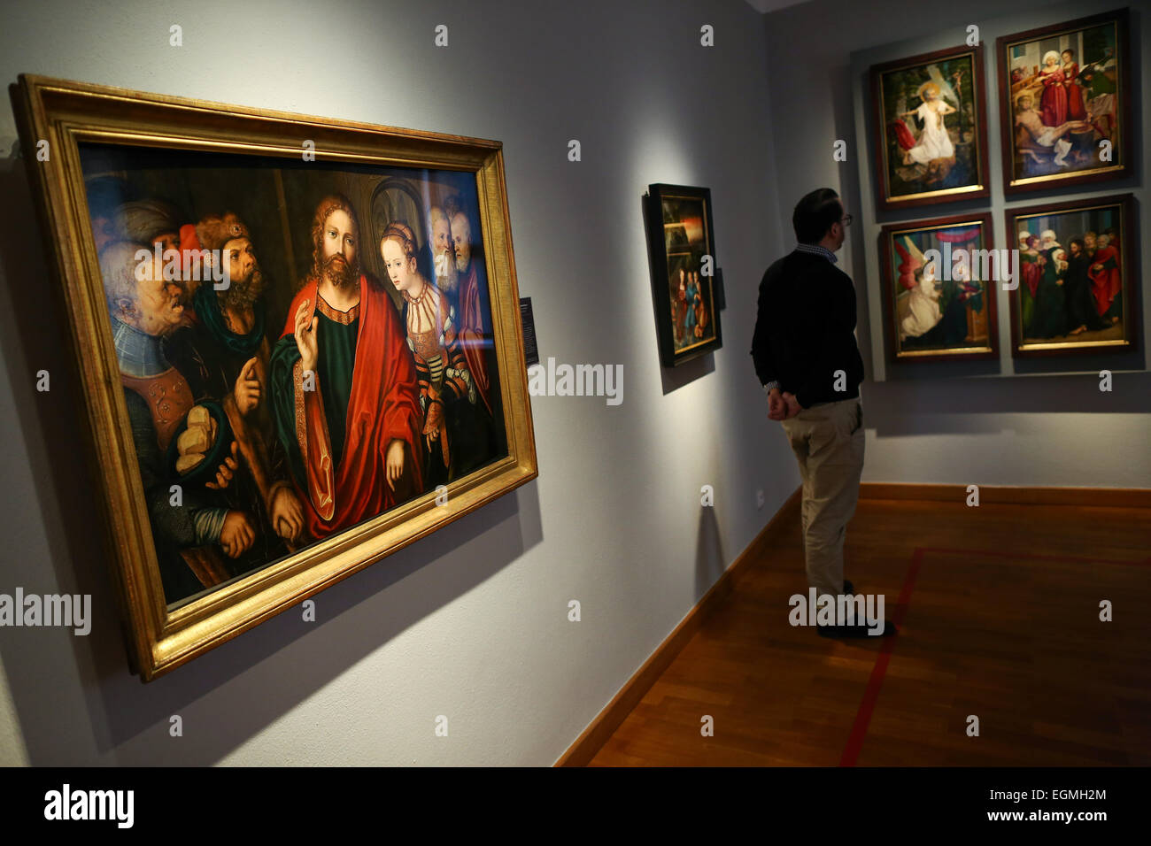 Kronach, Germania. 26 Febbraio, 2015. Un visitatore passeggiate passato il dipinto "Christus und die Ehebrecherin" (Cristo e l'adultera) dal pittore tedesco Lucas Cranach il Vecchio, sul display nel Cranach mostra presso il 'Fraenkische Galerie' exhibition venue in Kronach, Germania, 26 febbraio 2015. La famiglia di pittori Cranach, chiamato loro stessi dopo il loro paese di origine "Kronach' in Franconia. Foto: David Ebener/dpa/Alamy Live News Foto Stock
