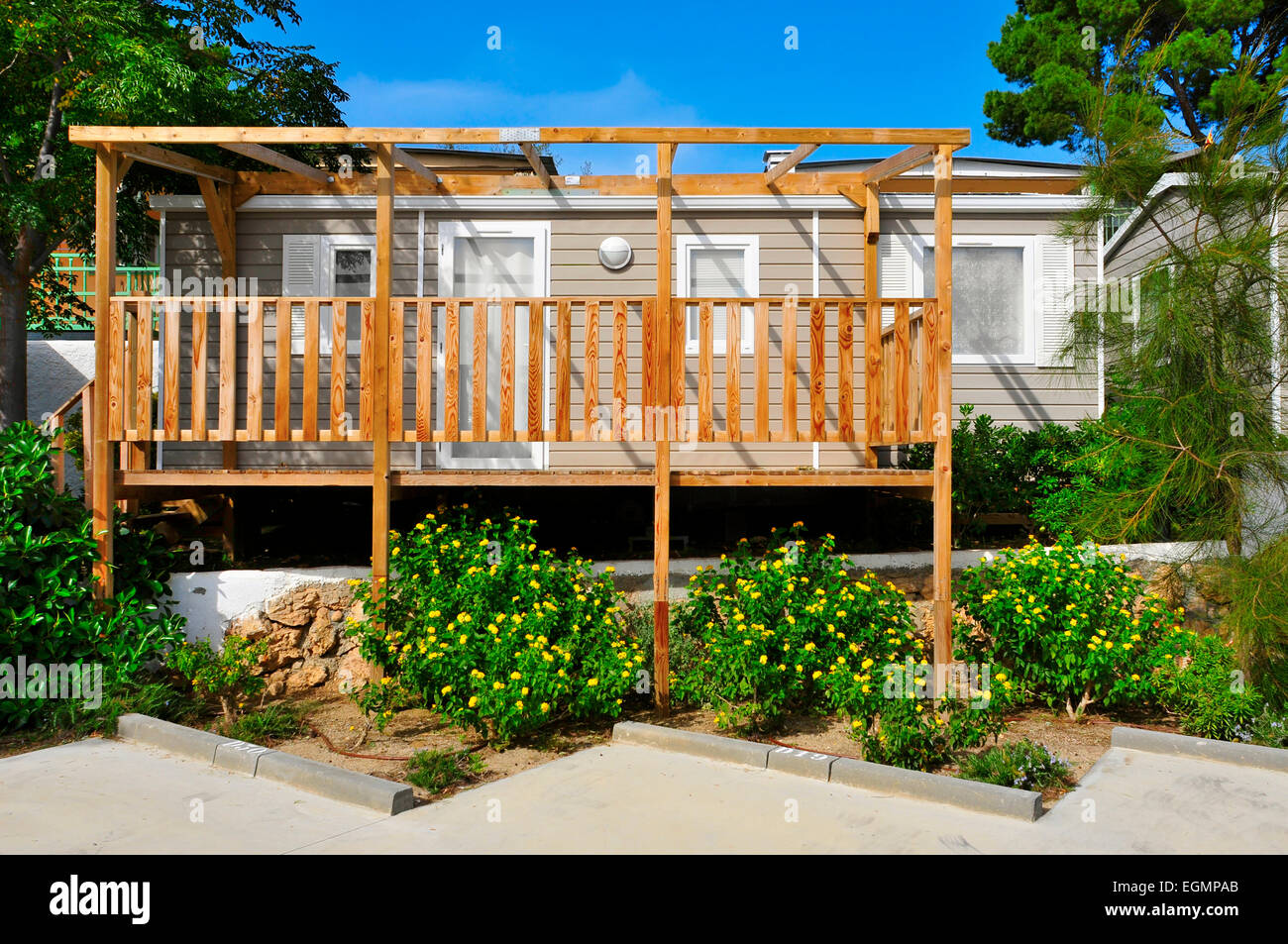 Una bella casa mobile con una veranda in legno in un campeggio Foto Stock