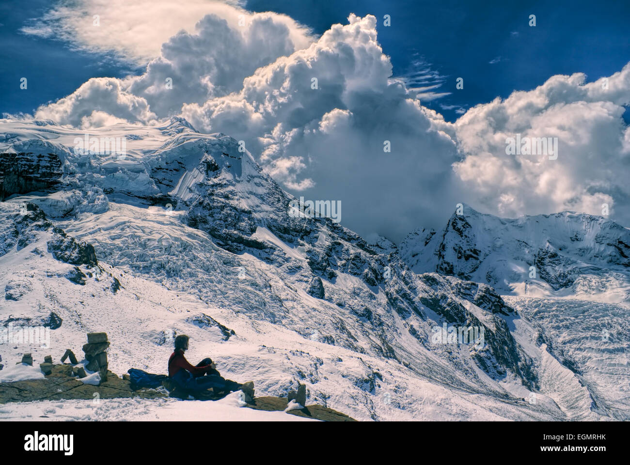Giovane escursionista seduto in sud americana Ande del Perù, Ausangate con drammatica la formazione di nubi sopra le montagne Foto Stock