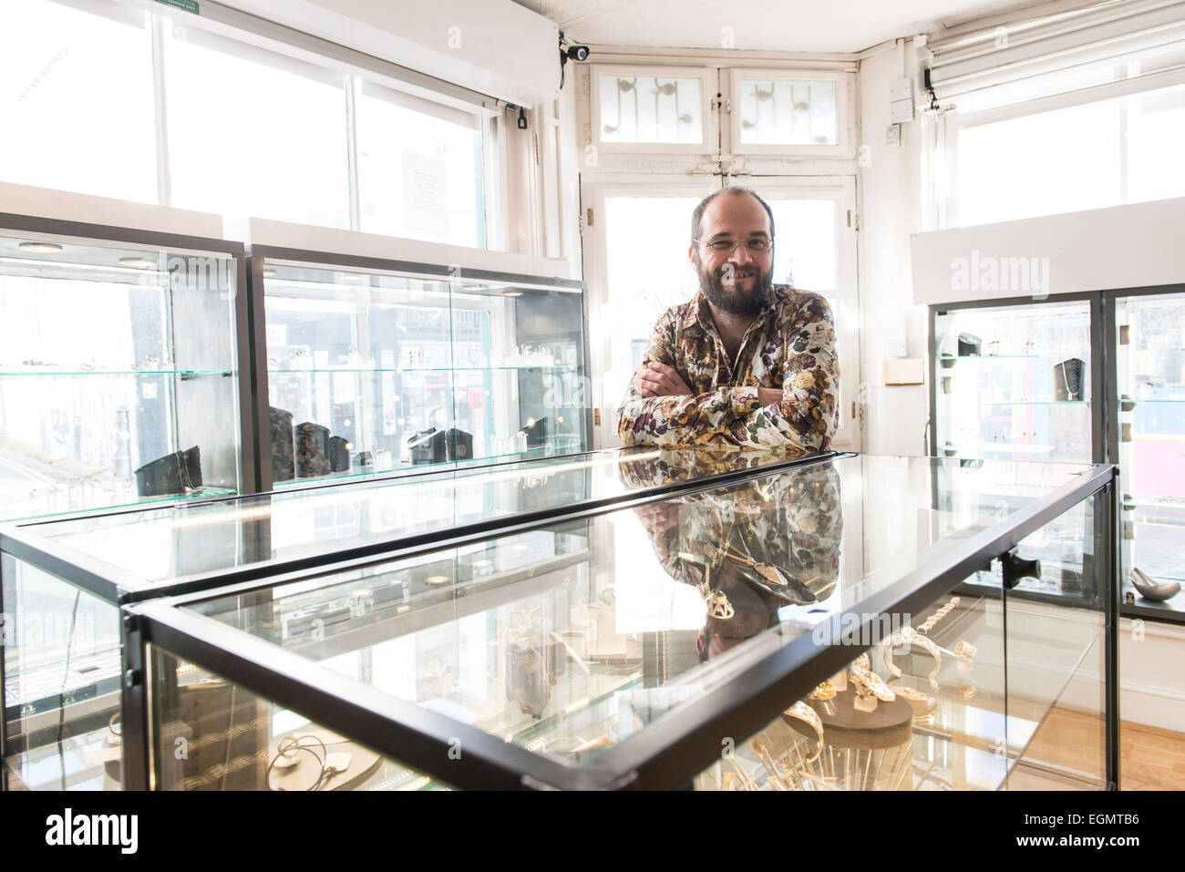 Dettagli e interno di gioiellieri shop, mostrando il proprietario, gli strumenti del commercio, arredi per negozi, prodotti e un uomo al lavoro Foto Stock