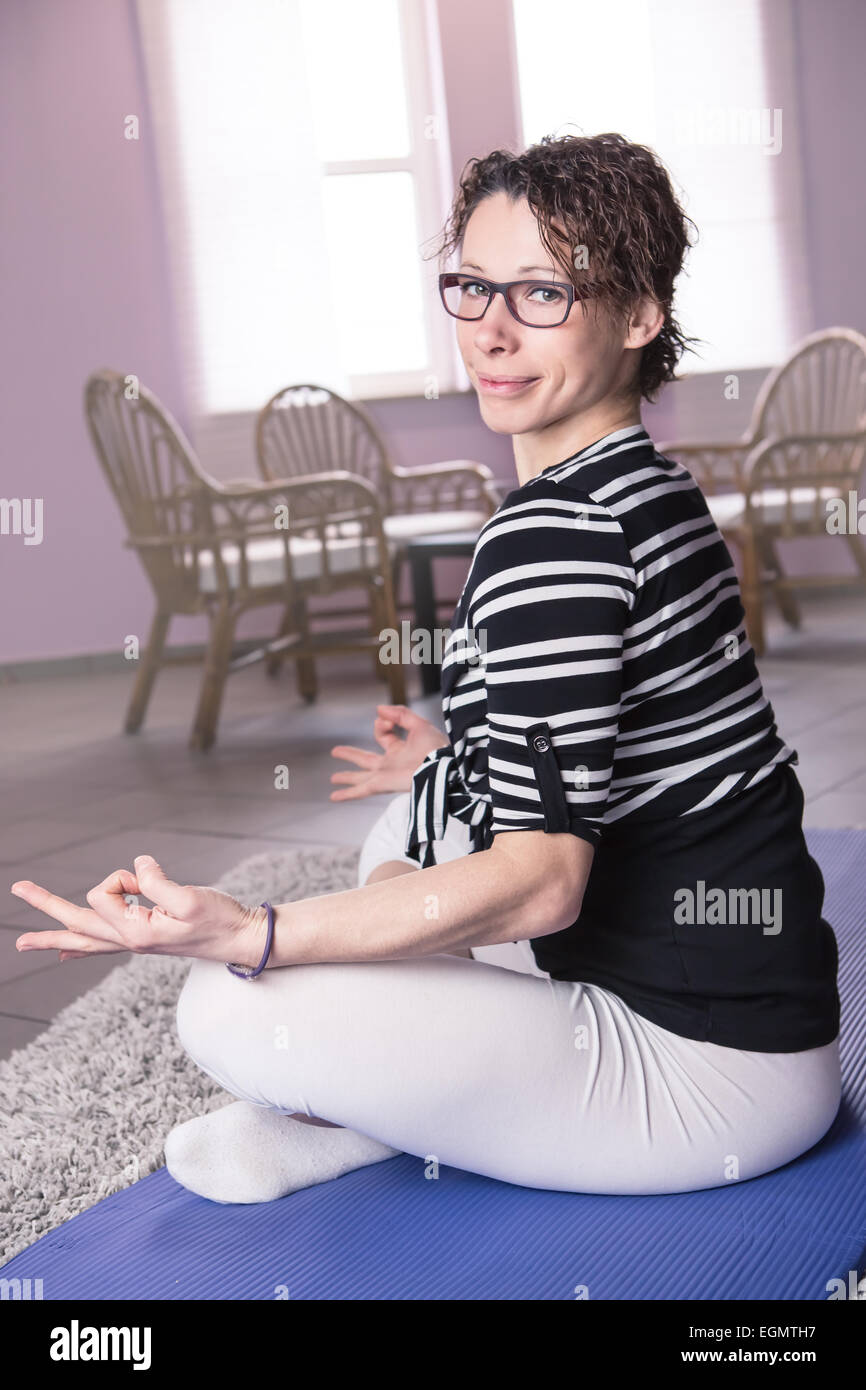 Una donna fare esercizi yoga a casa Foto Stock