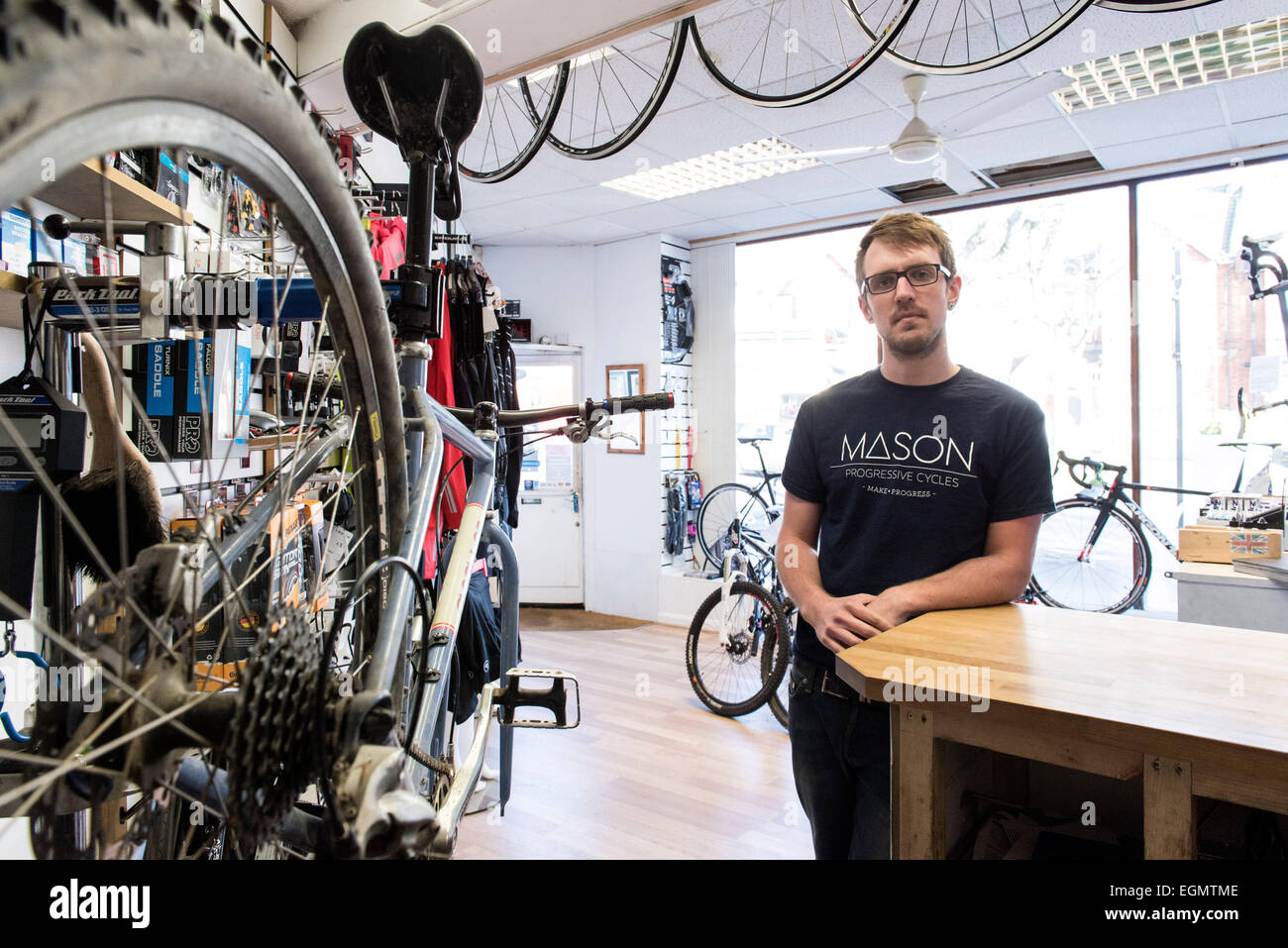 Un negoziante, titolare di una piccola azienda, meccanico di bicicletta si  erge nel suo negozio di ciclismo con le biciclette e altri prodotti di  ciclismo Foto stock - Alamy