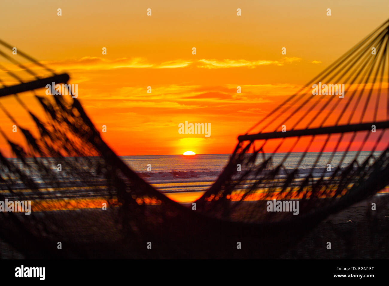 Amaca vuota nella parte anteriore del tramonto sulla spiaggia Foto Stock