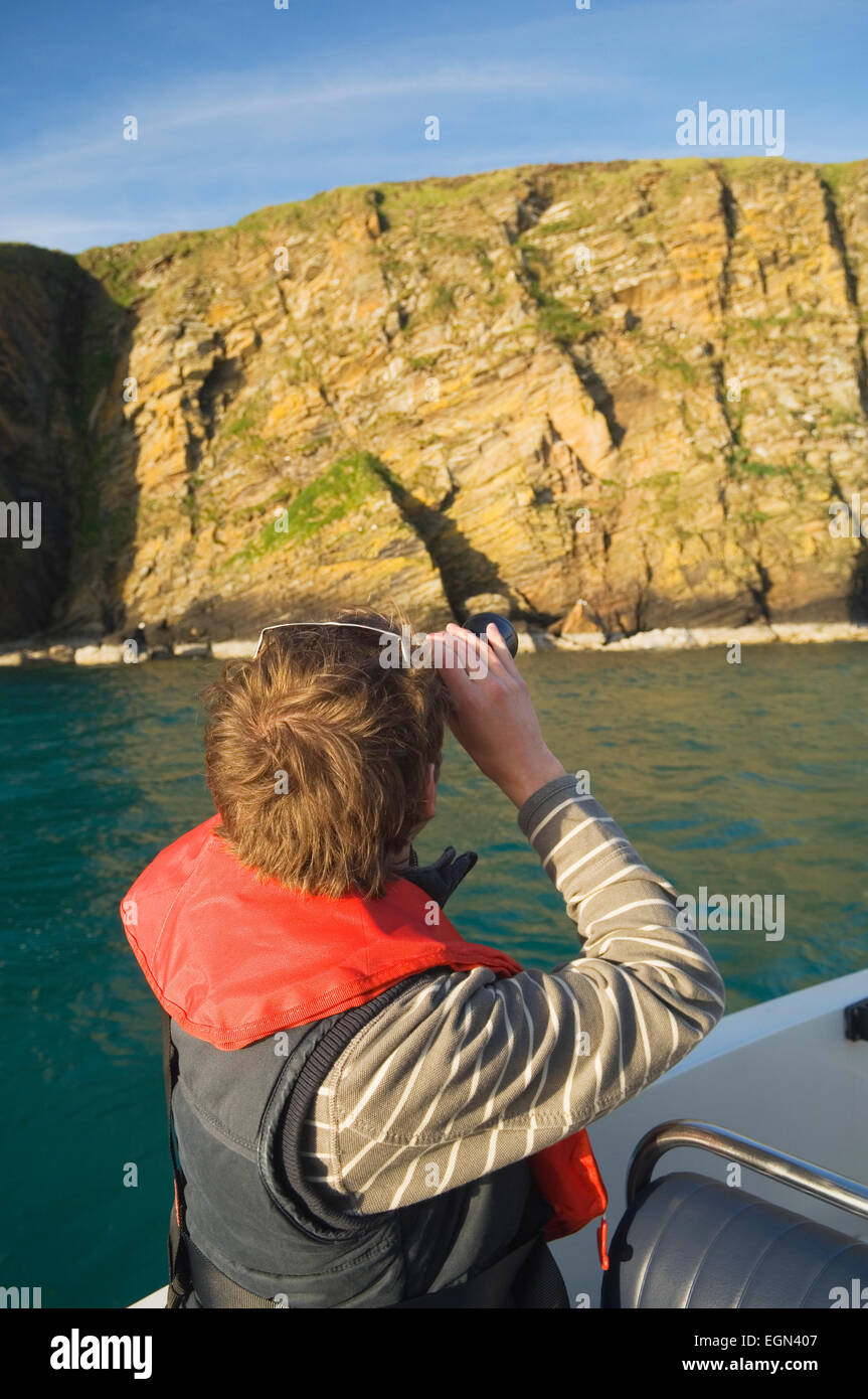 Coppia giovane birdwatching a bordo di una barca in Scapa Flow, Orkney Islands, Scozia. Foto Stock