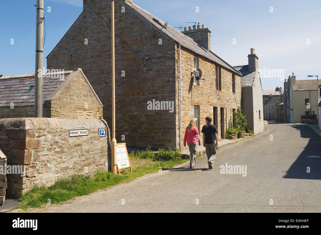 Coppia giovane camminando attraverso le strade di St Margaret's speranza - South Ronaldsay, Orkney Islands, Scozia. Foto Stock