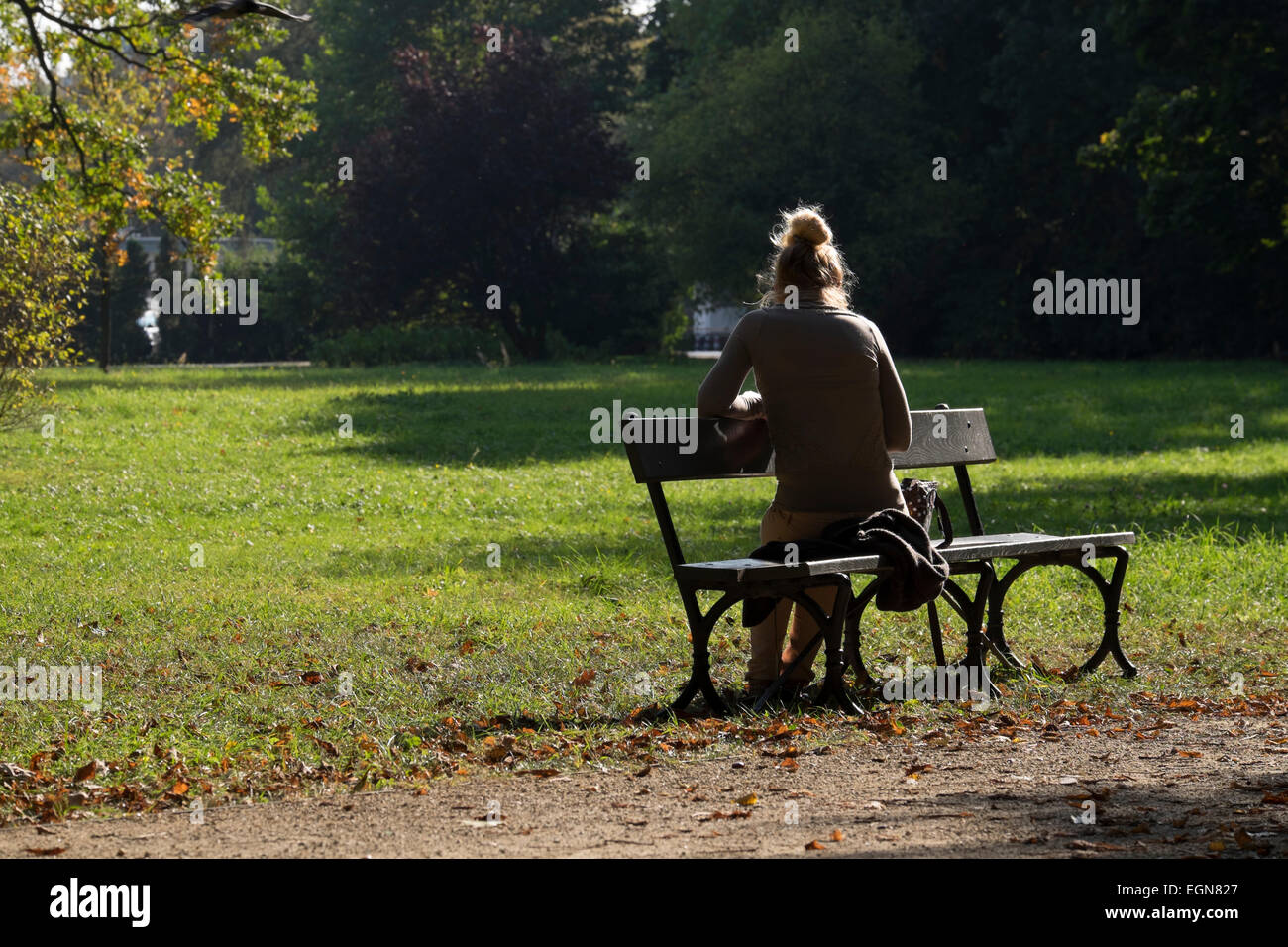 Attraente ragazza leggendo un libro in un caldo pomeriggio di sole nel parco Lazienkowski, Varsavia Foto Stock