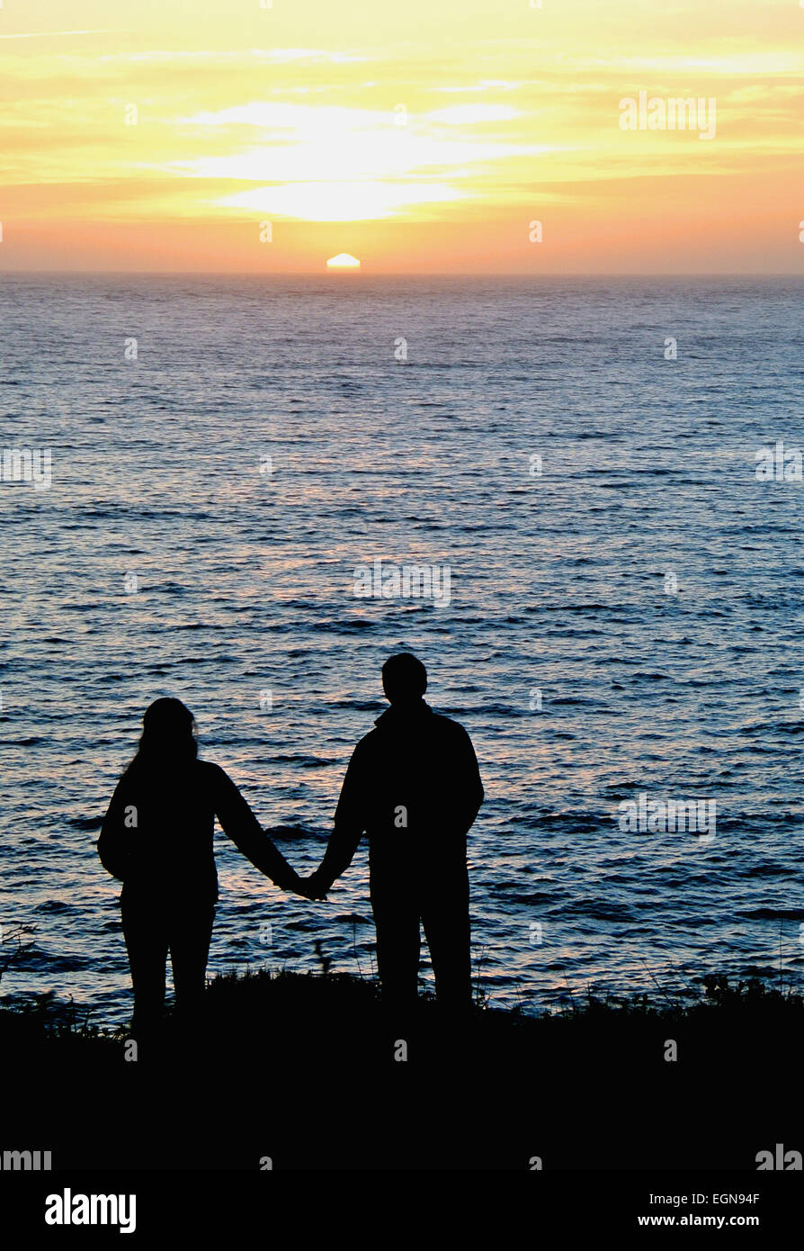 Giovane tenendo le mani al tramonto nella costa della California città di Mendocino Foto Stock