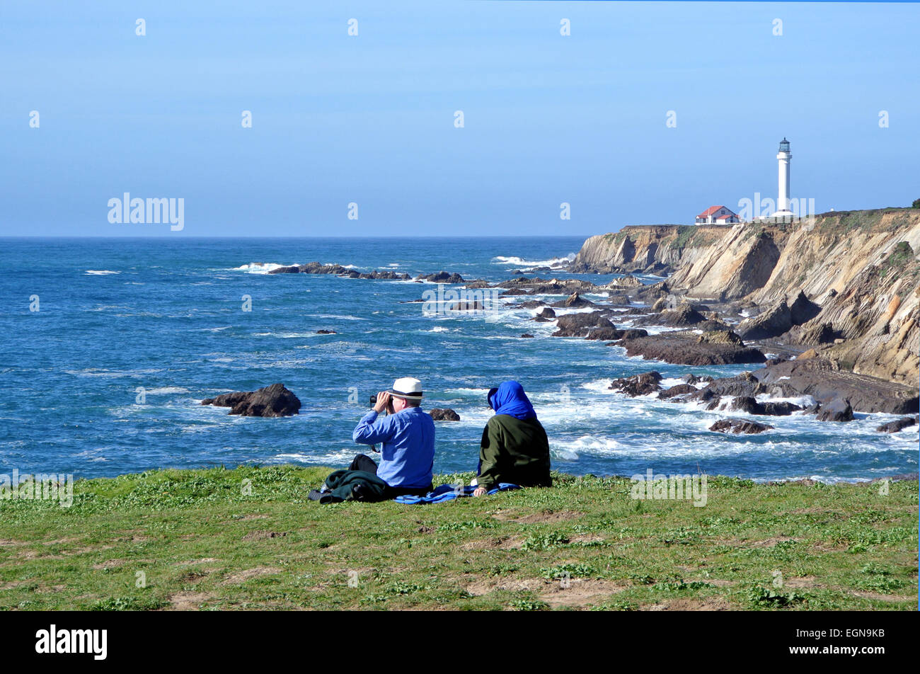 L uomo e la donna cercano le balene off costa della California al punto arena faro in Mendocino County Foto Stock