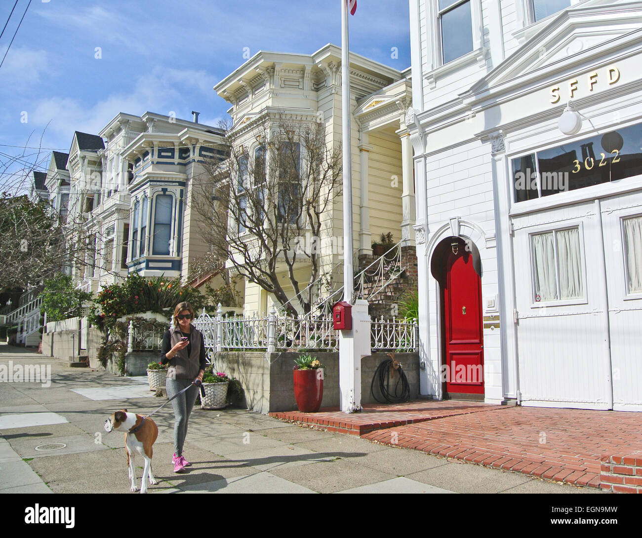 Signora passeggiate cane in filmore passato storico, di san francisco firehouse in Washington Street vicino a fillmore e washinton strade Foto Stock