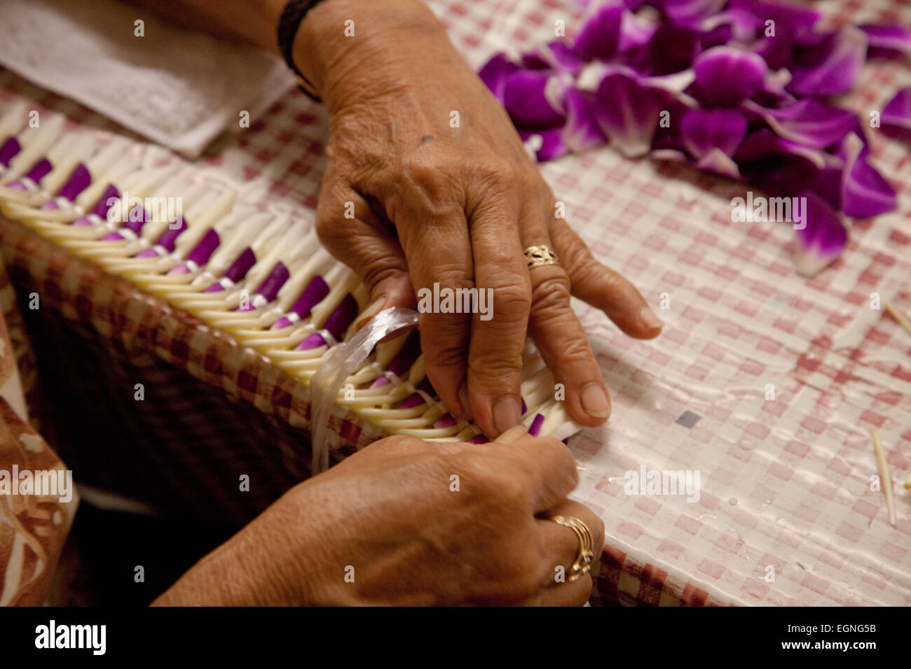 Donna che fa una ghirlanda di fiori in Hawaii. Foto Stock